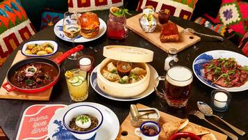 A table set with various dishes, drinks, and a decorative pillow.