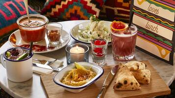 A table set with various dishes, drinks, and a menu card.
