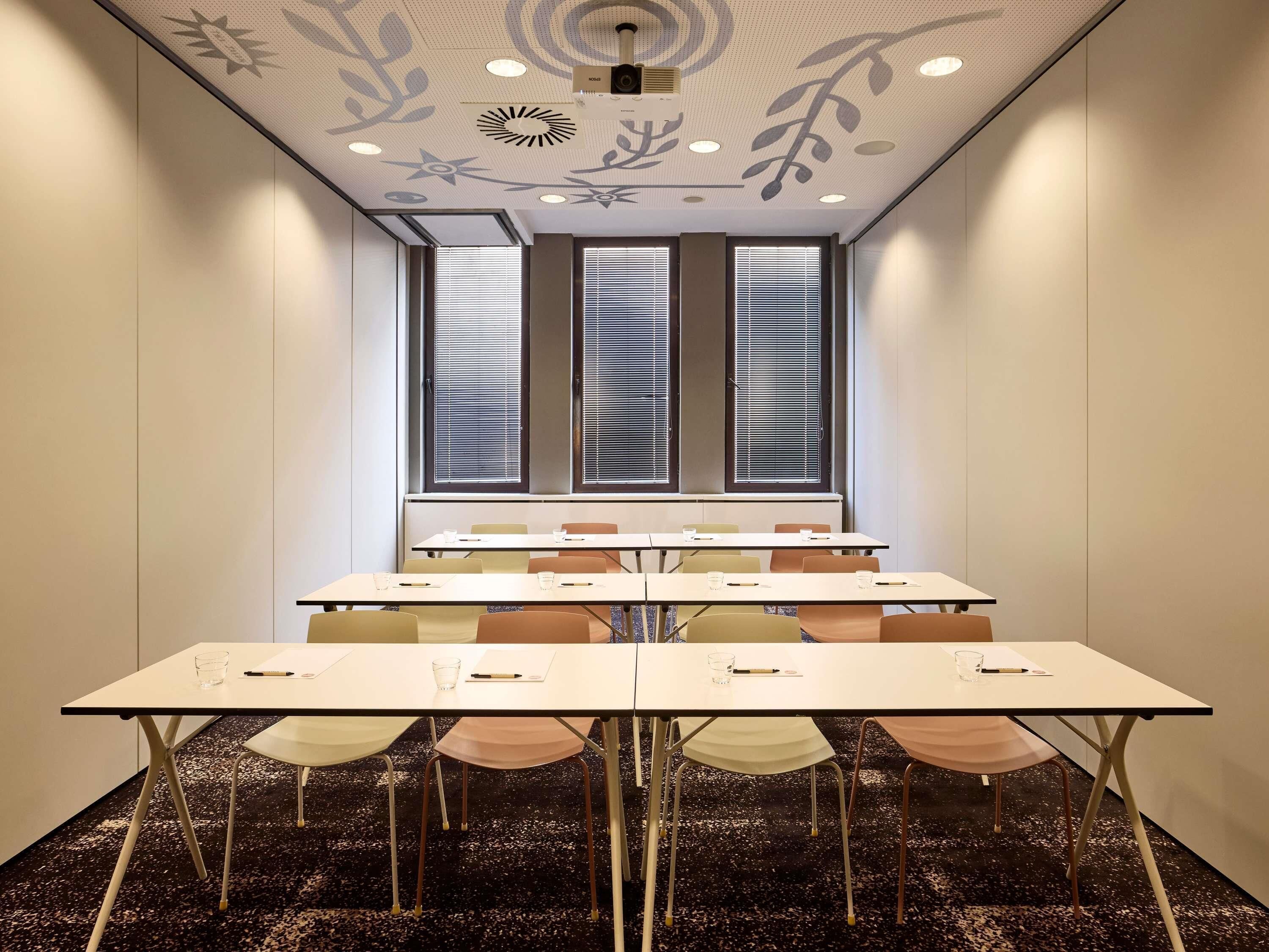 A conference room with a long table, chairs, and a ceiling with decorative patterns.