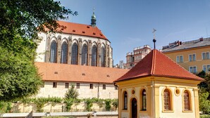 A historic building with a red-tiled roof and a smaller yellow structure with arched windows. - Adria Hotel Prague (Prague)