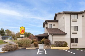 Un motel con estacionamiento, un letrero de Super 8 y un edificio con techo inclinado.