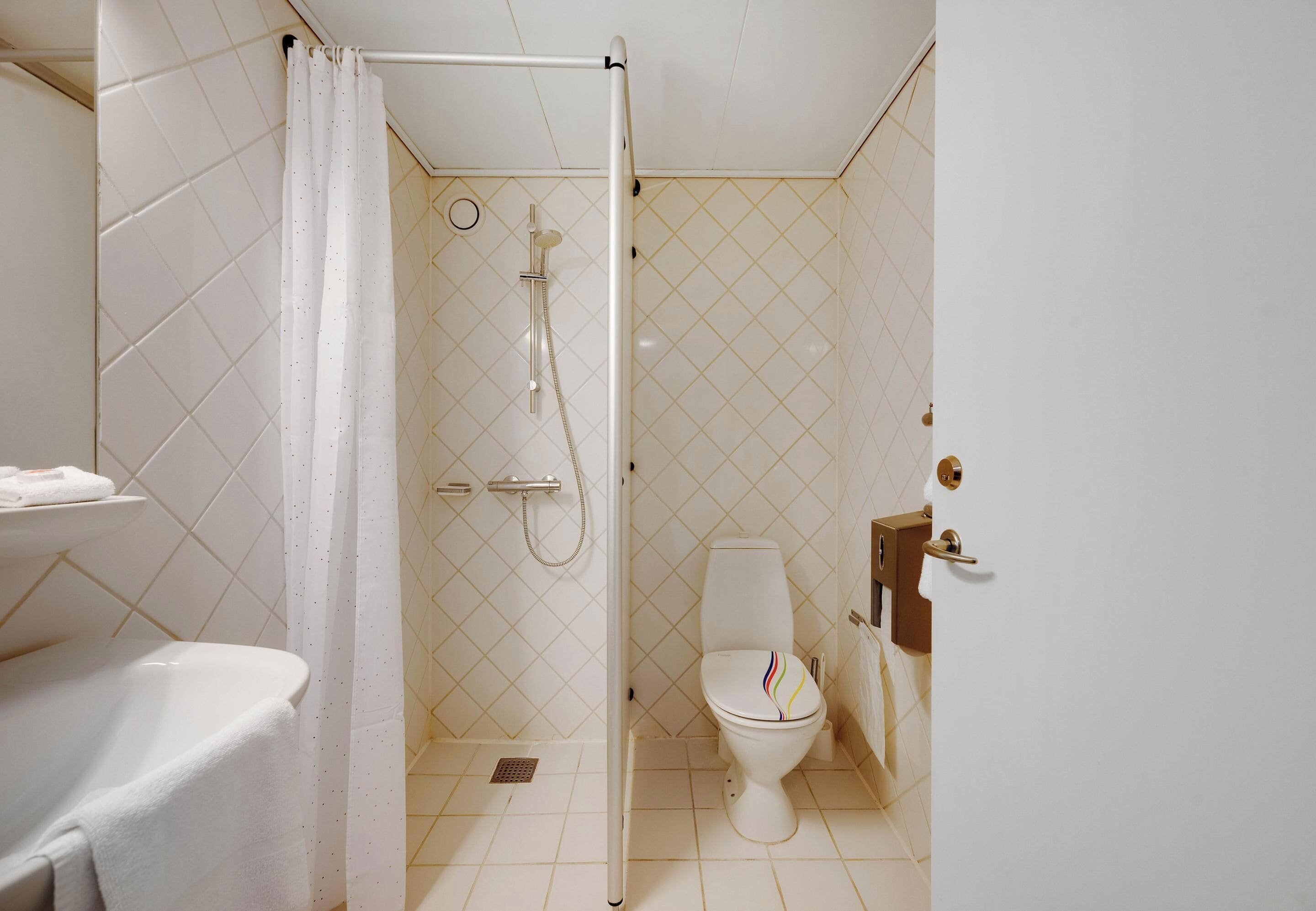 Un baño con ducha, inodoro y lavamanos.