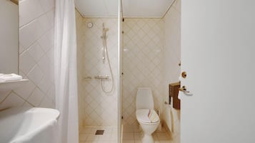 Un baño con ducha, inodoro y lavamanos.