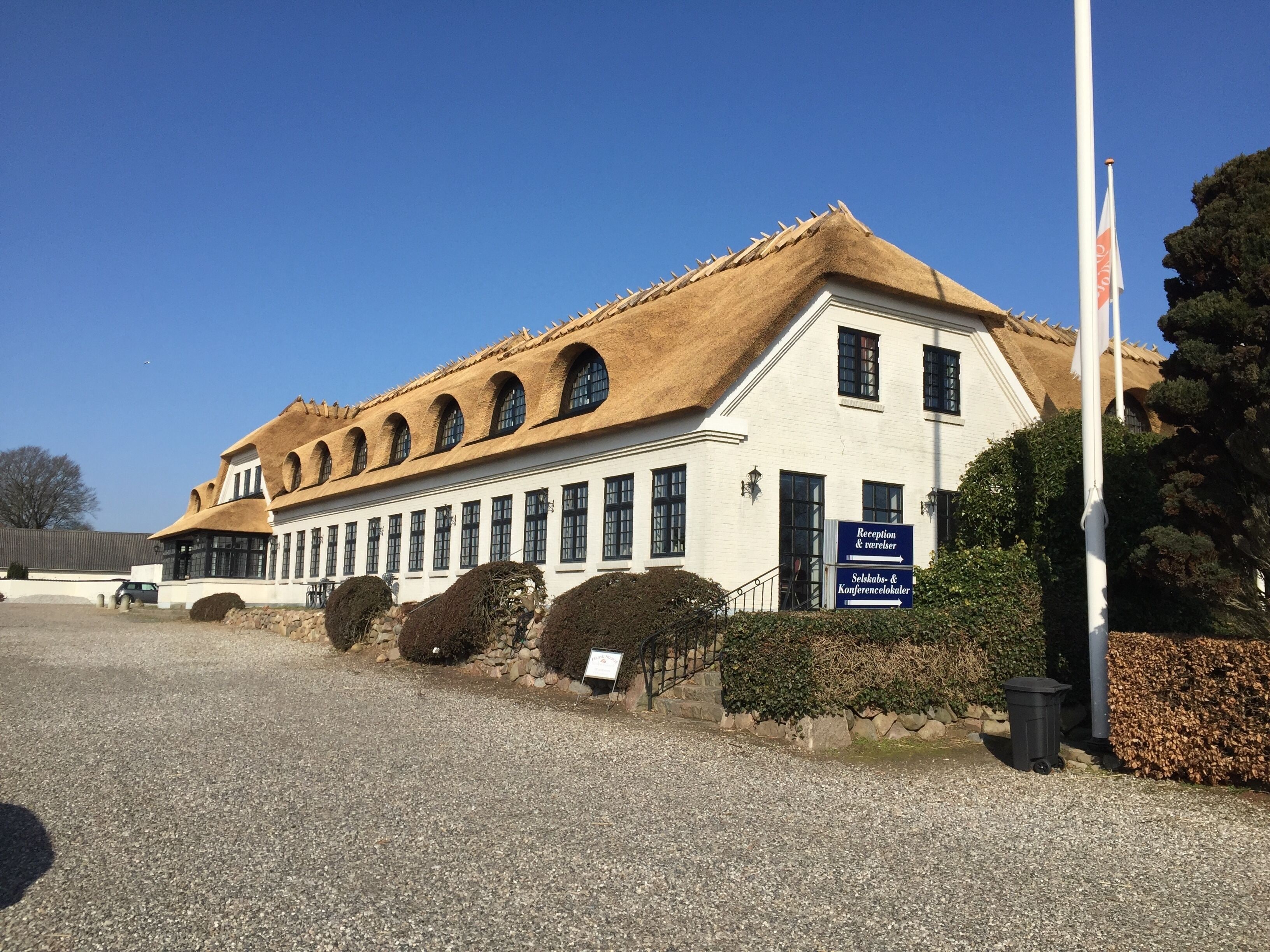 A building with a traditional architectural style, featuring a steeply pitched roof and multiple arched windows.