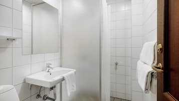 Baño con lavamanos blanco, espejo y cortina de ducha.