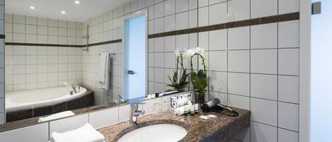 Un baño moderno con un lavabo grande, espejo y bañera.