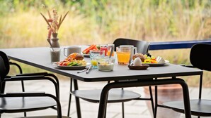 A breakfast table with various dishes, drinks, and a vase of dried flowers. - Best Western Hotel Hillerod (Hillerod)