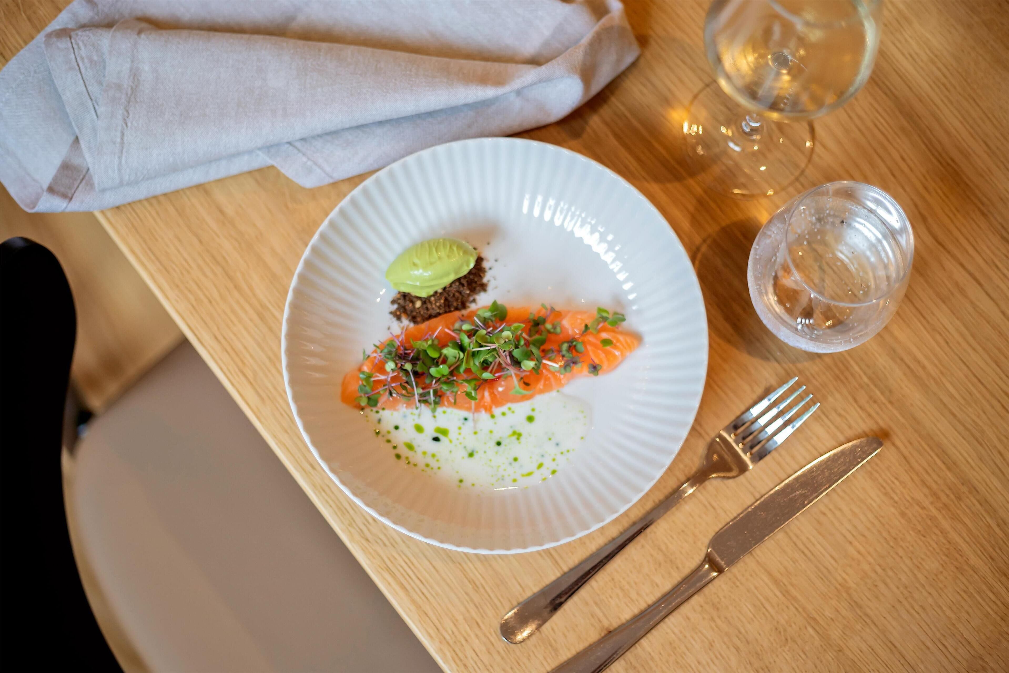 Un plato de comida con tenedor y cuchillo sobre una mesa de madera.