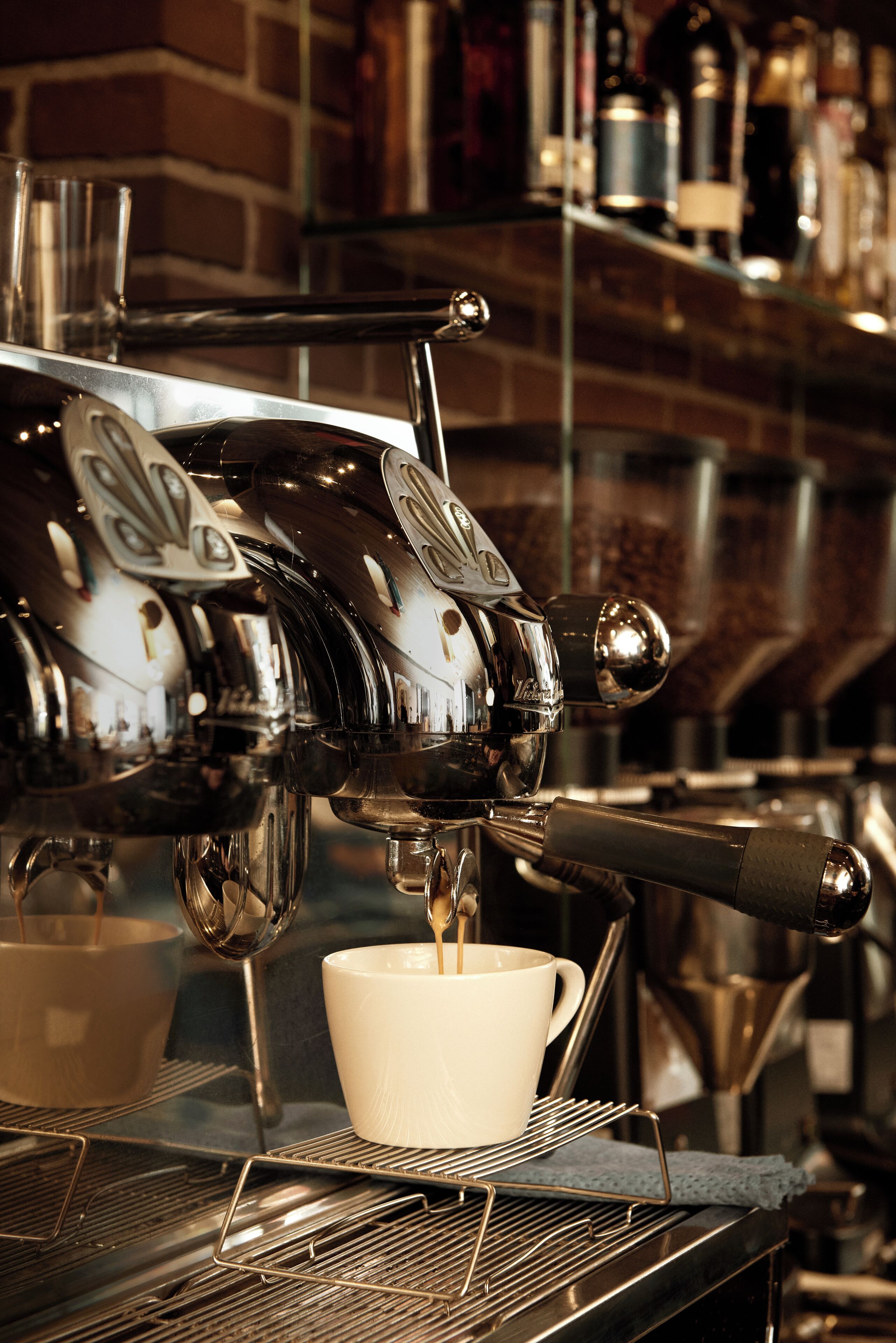 En kaffemaskine tapper kaffe i en kop.