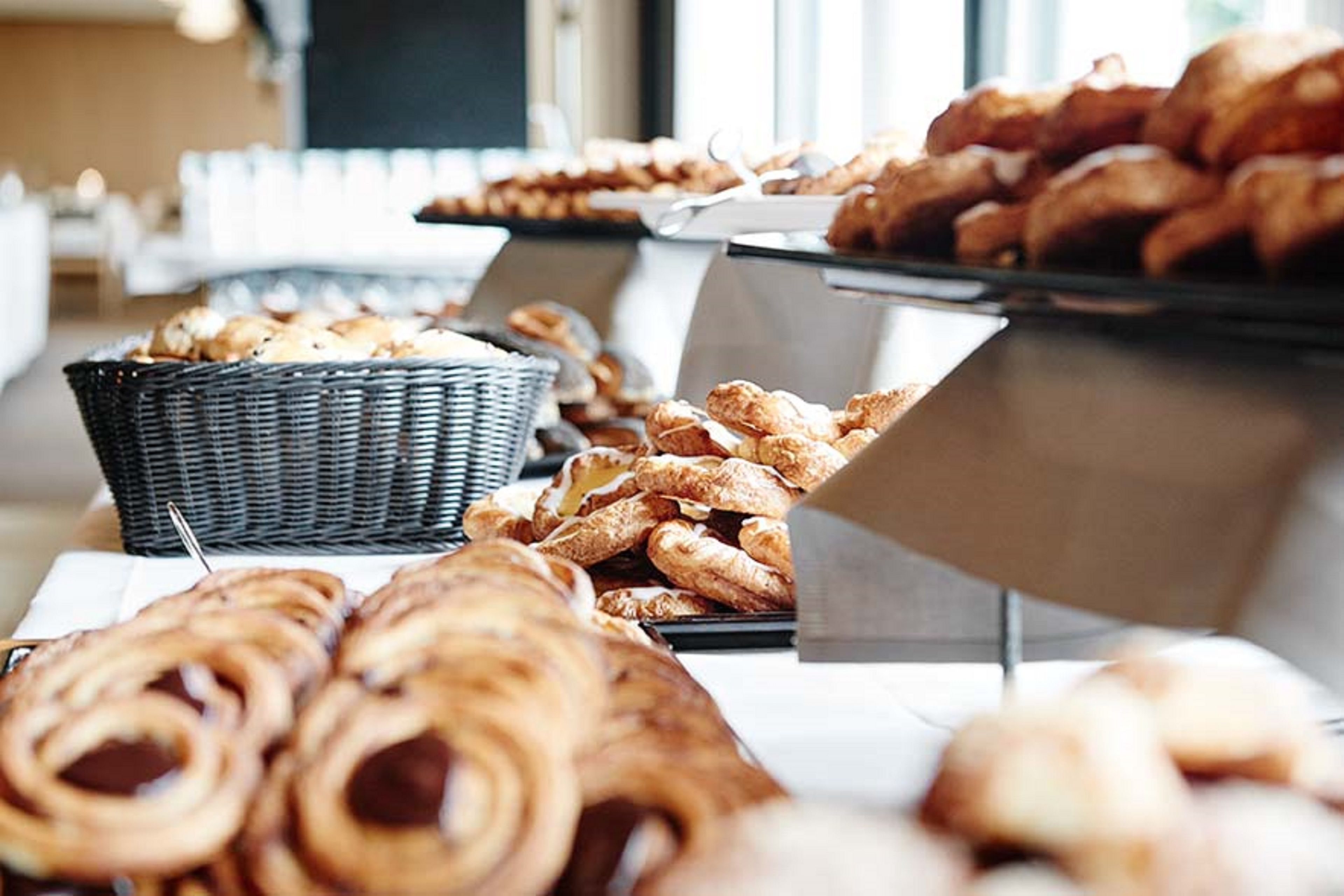Un bufé con diversos pasteles y productos de panadería.