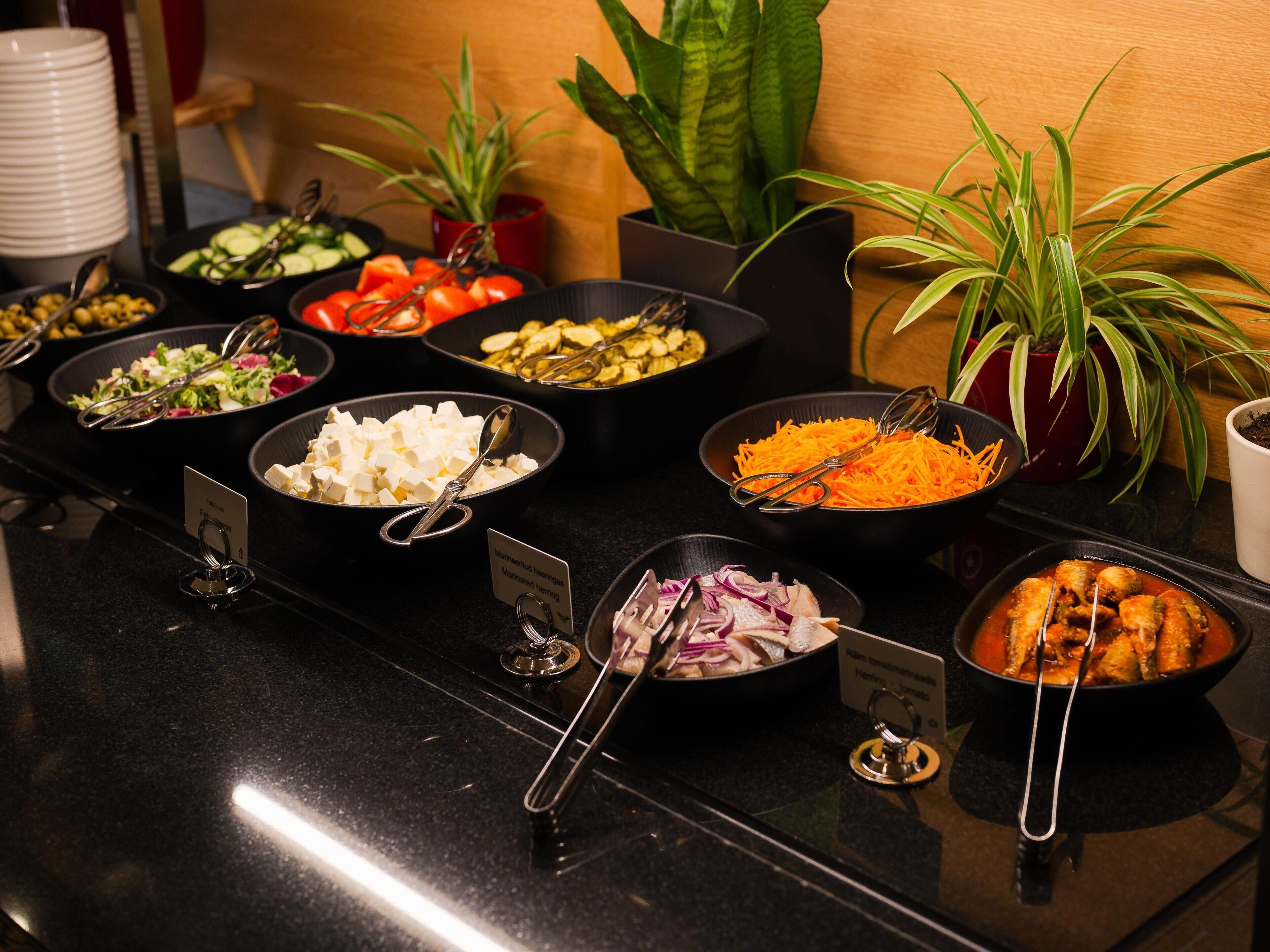 Een buffet met diverse gerechten en bestek.