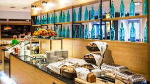A buffet area with various food items and a display of green glass bottles. - Park Inn by Radisson Central Tallinn (Tallinn)