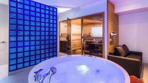 A modern bathroom with a large bathtub, a glass shower enclosure, and a wooden sauna area. - Park Inn by Radisson Central Tallinn (Tallinn)