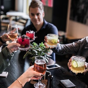 A group of people at a bar holding drinks. - Hotel Helka (Helsinki)