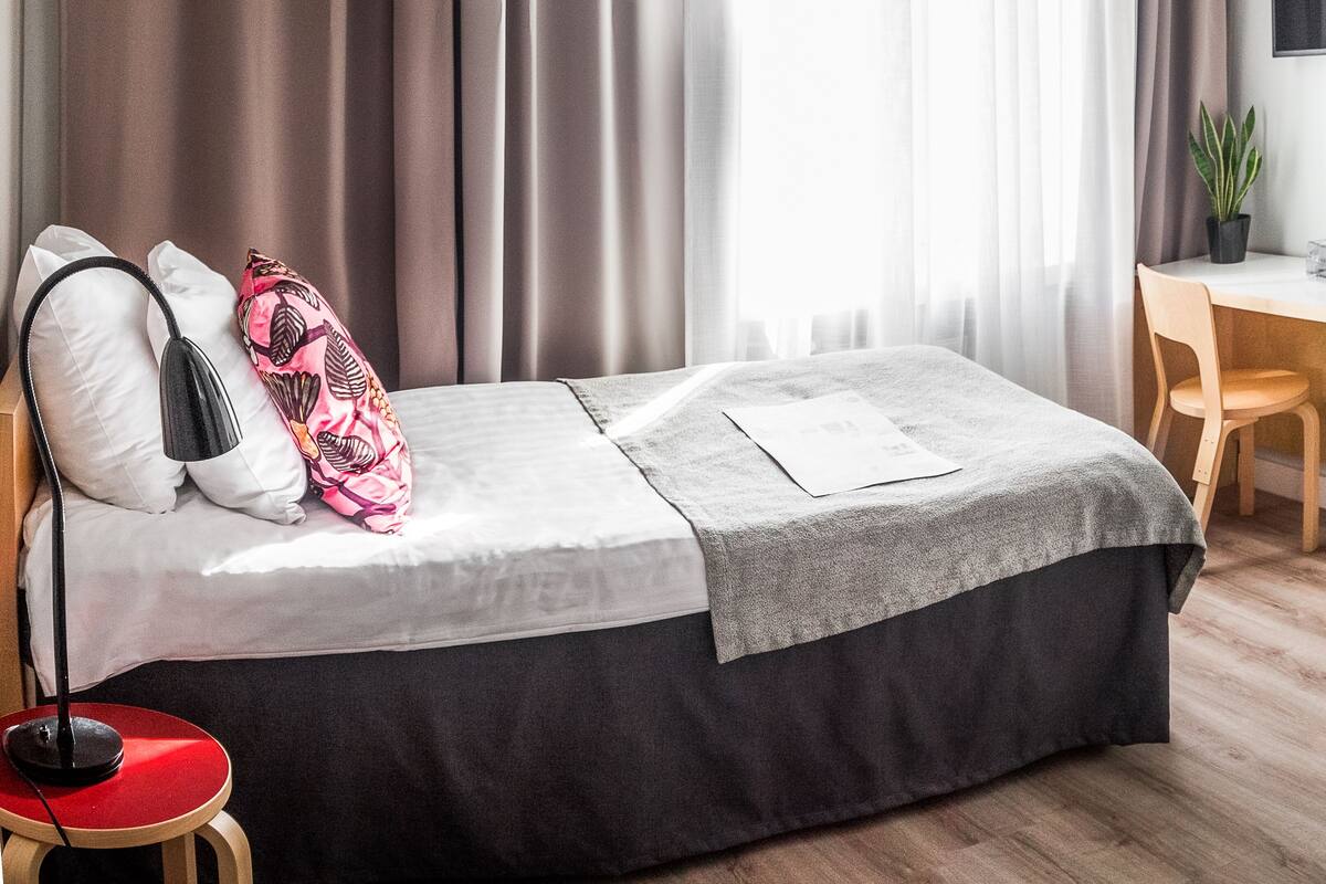 Un dormitorio moderno con cama, escritorio y silla.