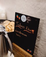 A box of Fika cardamom buns with a label that reads "Todays Fika cardamom buns" and a "Home until you're home" sticker.
