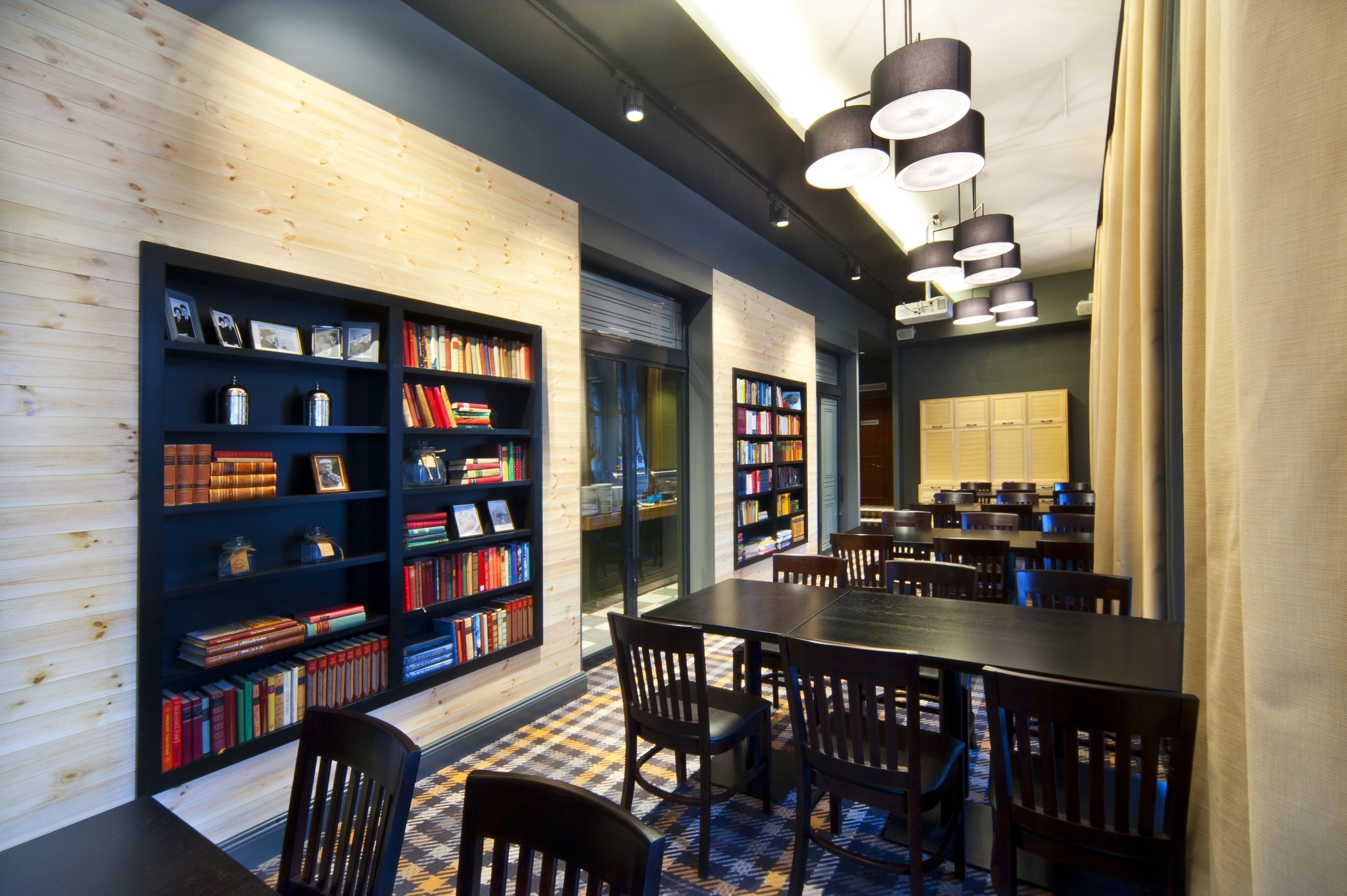 A library with bookshelves, a long table, and chairs.