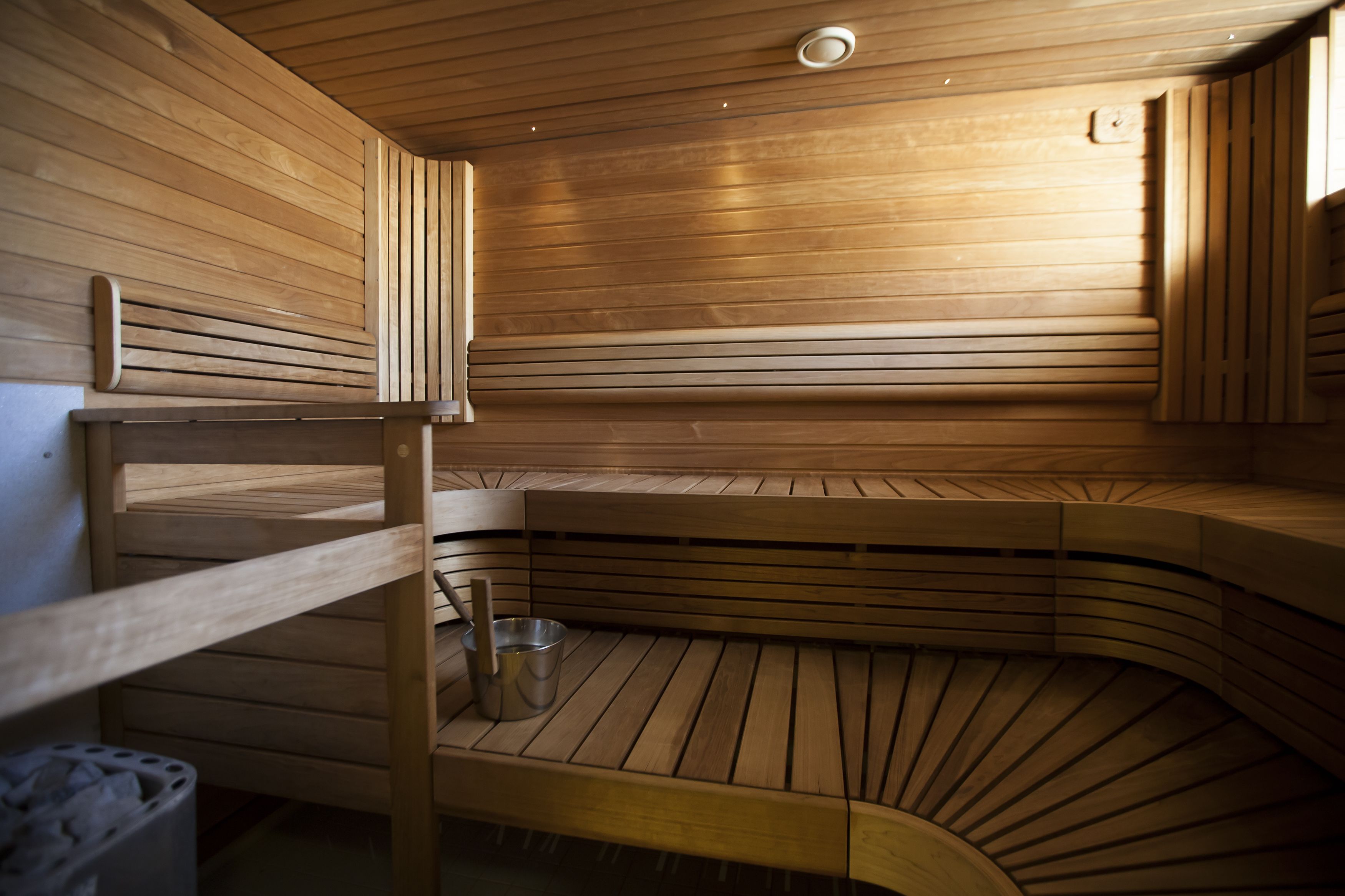 Uma sauna de madeira com bancos e um balde.