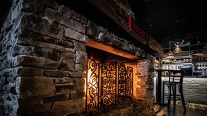 A stone building with a wrought iron gate and a sign above it. - Hotel Oscar (Varkaus)