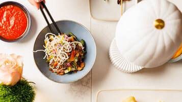 A table with various dishes, including skewers, noodles, and a bowl of soup.