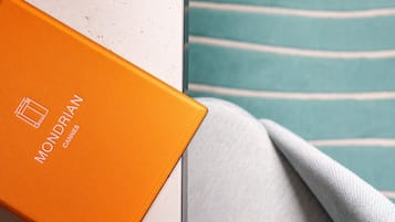 A white marble surface with a folded grey fabric and an orange box with "Mondrian" text.