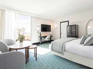 A hotel room with a bed, a desk, a chair, a TV, and a window. - Mondrian Cannes (Cannes)