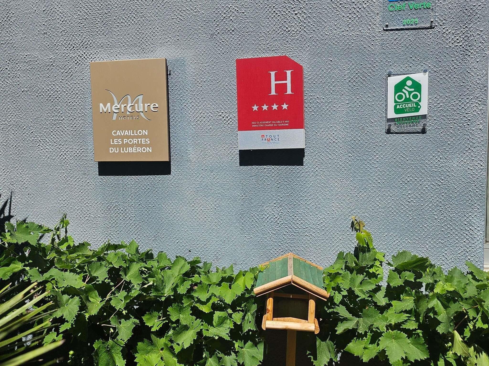A hotel sign with a red 'H' and a welcome sign for cyclists.