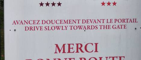 A sign with logos of Mercure and ibis hotels, a directional instruction in French, and a thank you message.