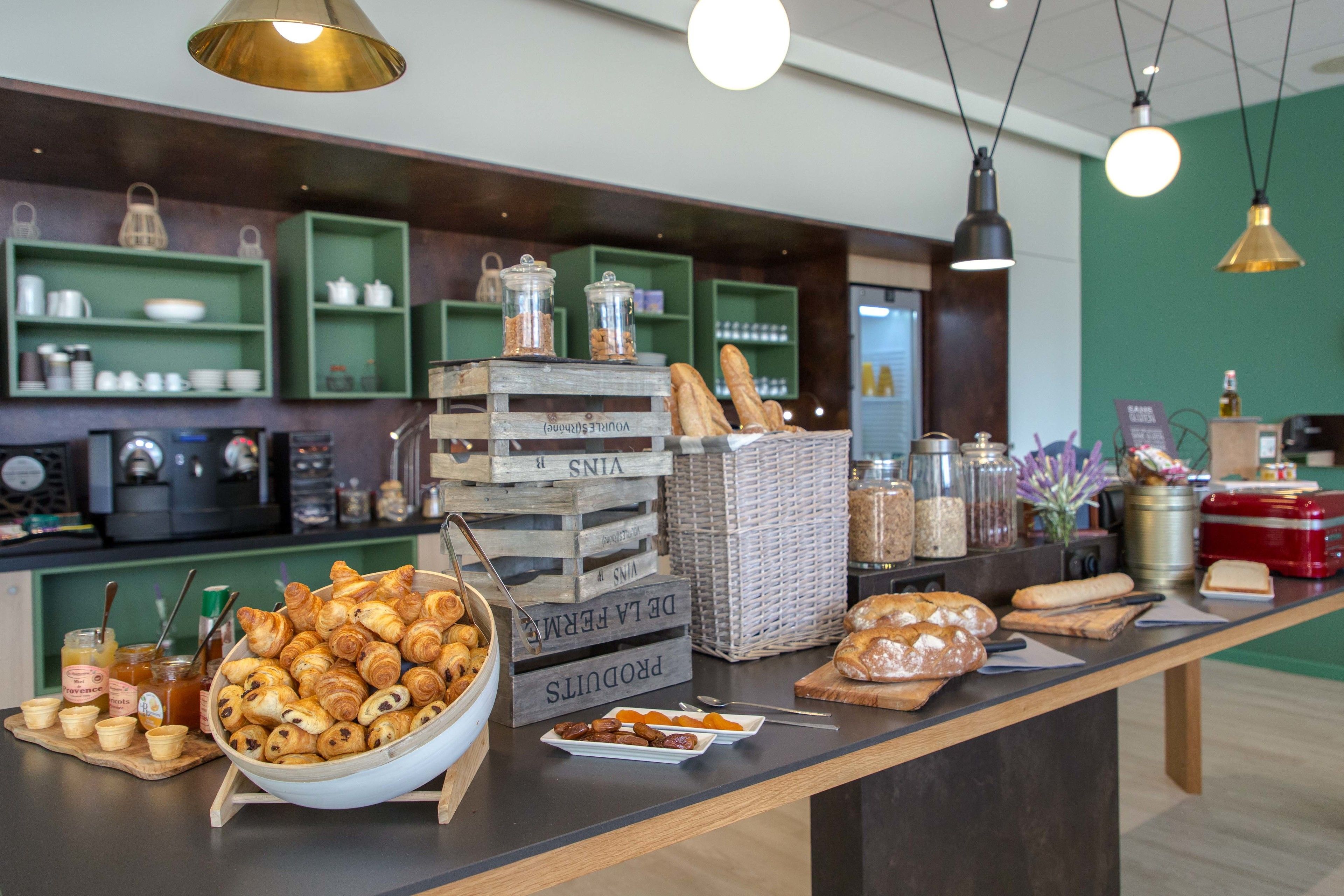 A breakfast buffet with various pastries, bread, and condiments.