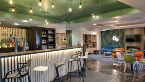 Een moderne bar met een toog, barkrukken en diverse glazen.