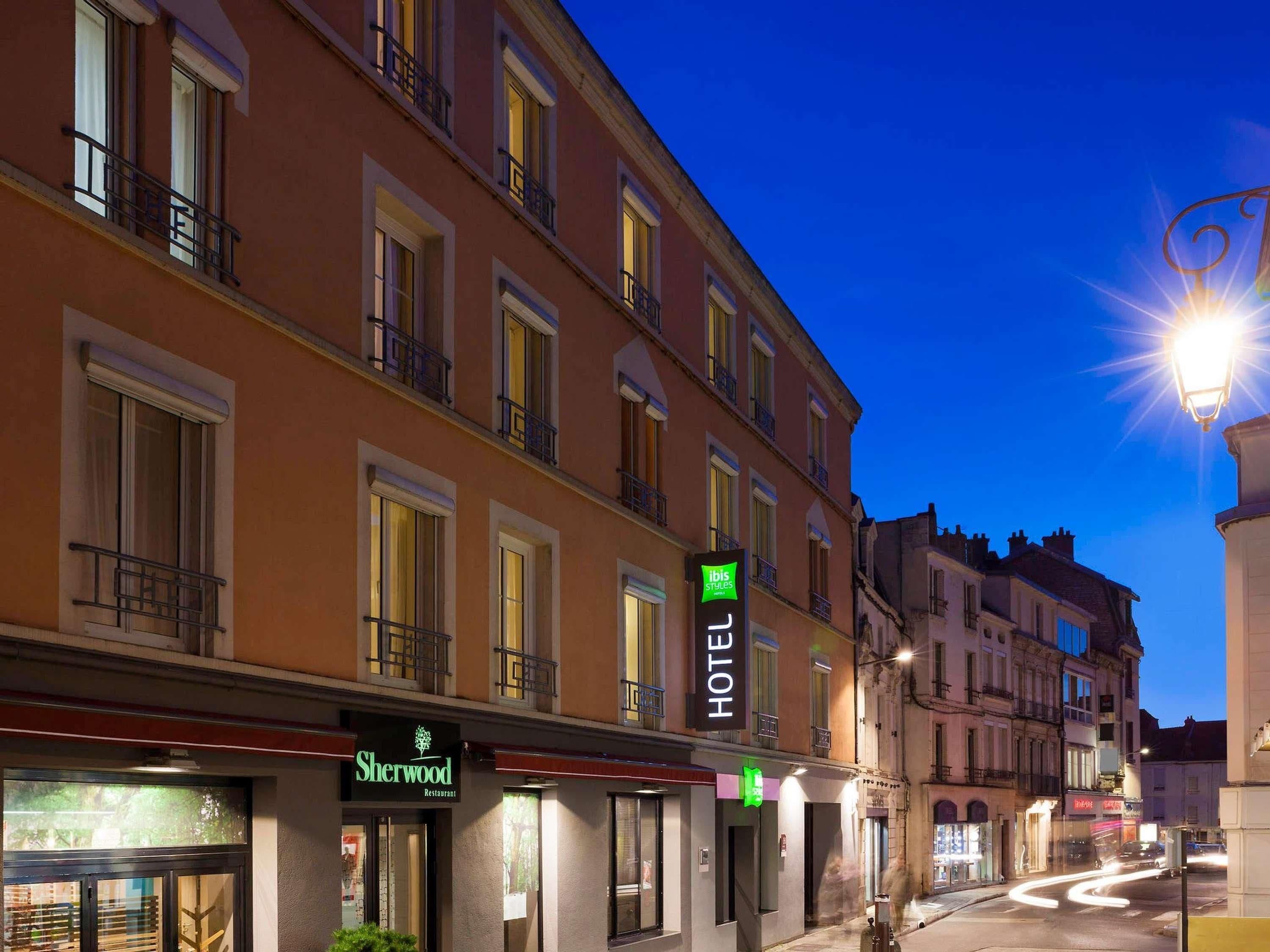 Een hotel met een bord waarop 'Sherwood Restaurant' en 'ibis Styles' staat.