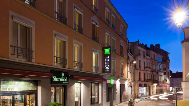 A hotel with a sign indicating 'Sherwood Restaurant' and 'ibis Styles' on the facade.