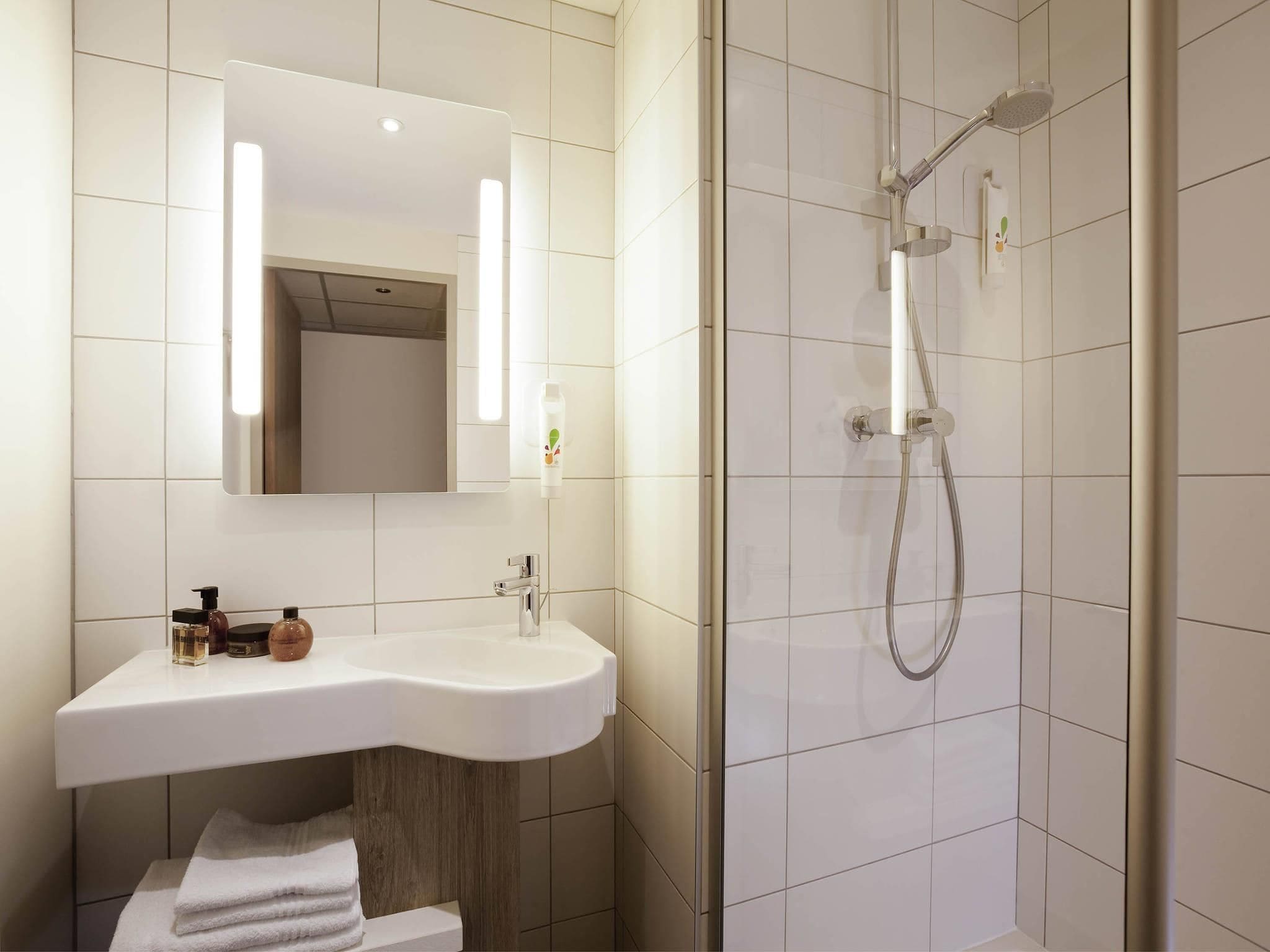 Ein Badezimmer mit Waschbecken, Spiegel und Dusche.