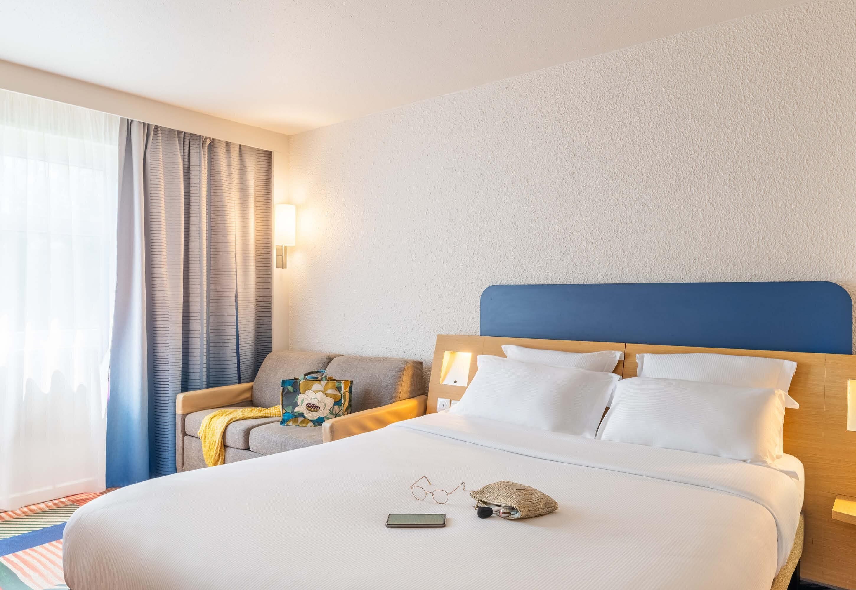 Une chambre d’hôtel avec un grand lit, un canapé et une table de chevet.