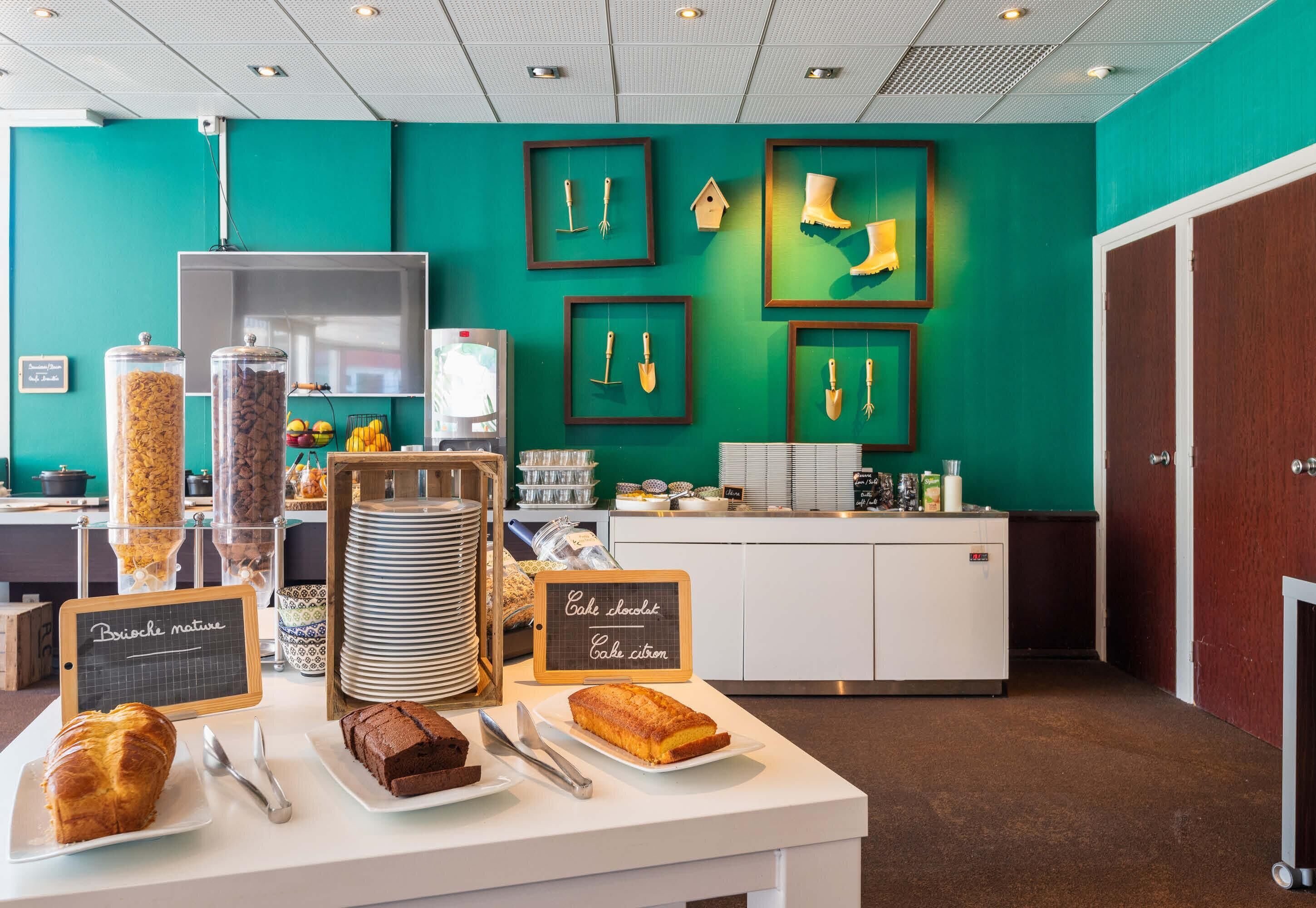 A breakfast buffet with various food items and a chalkboard sign indicating cake options.