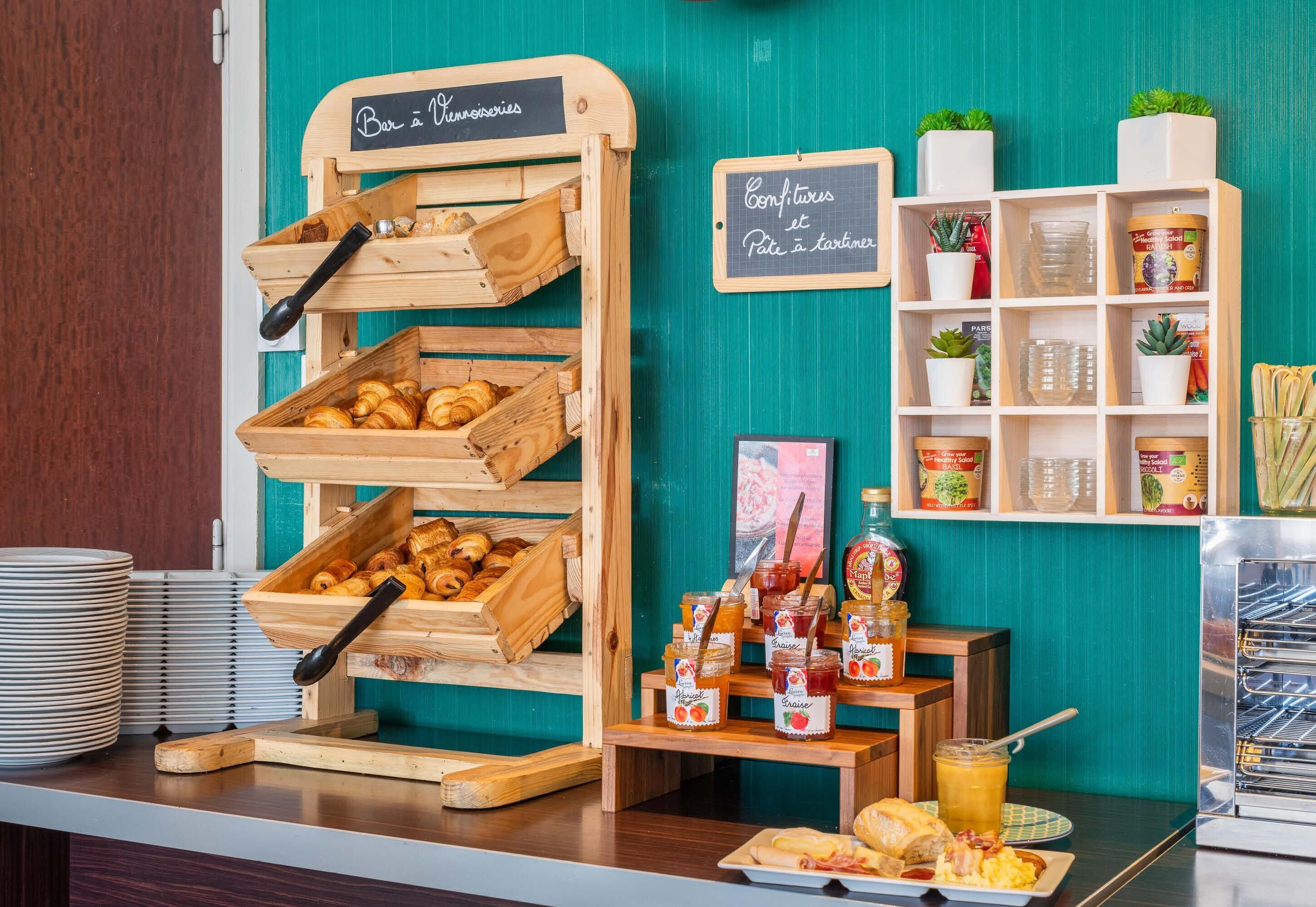 A bakery display with croissants and jams, wooden crates, and a chalkboard menu.