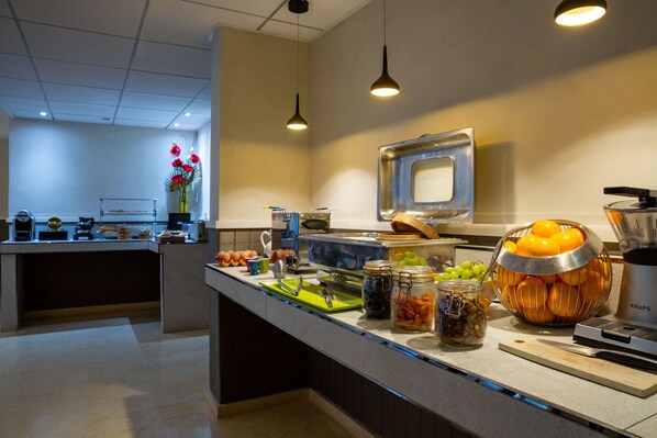 A modern kitchen with a buffet setup, including various food items and utensils.