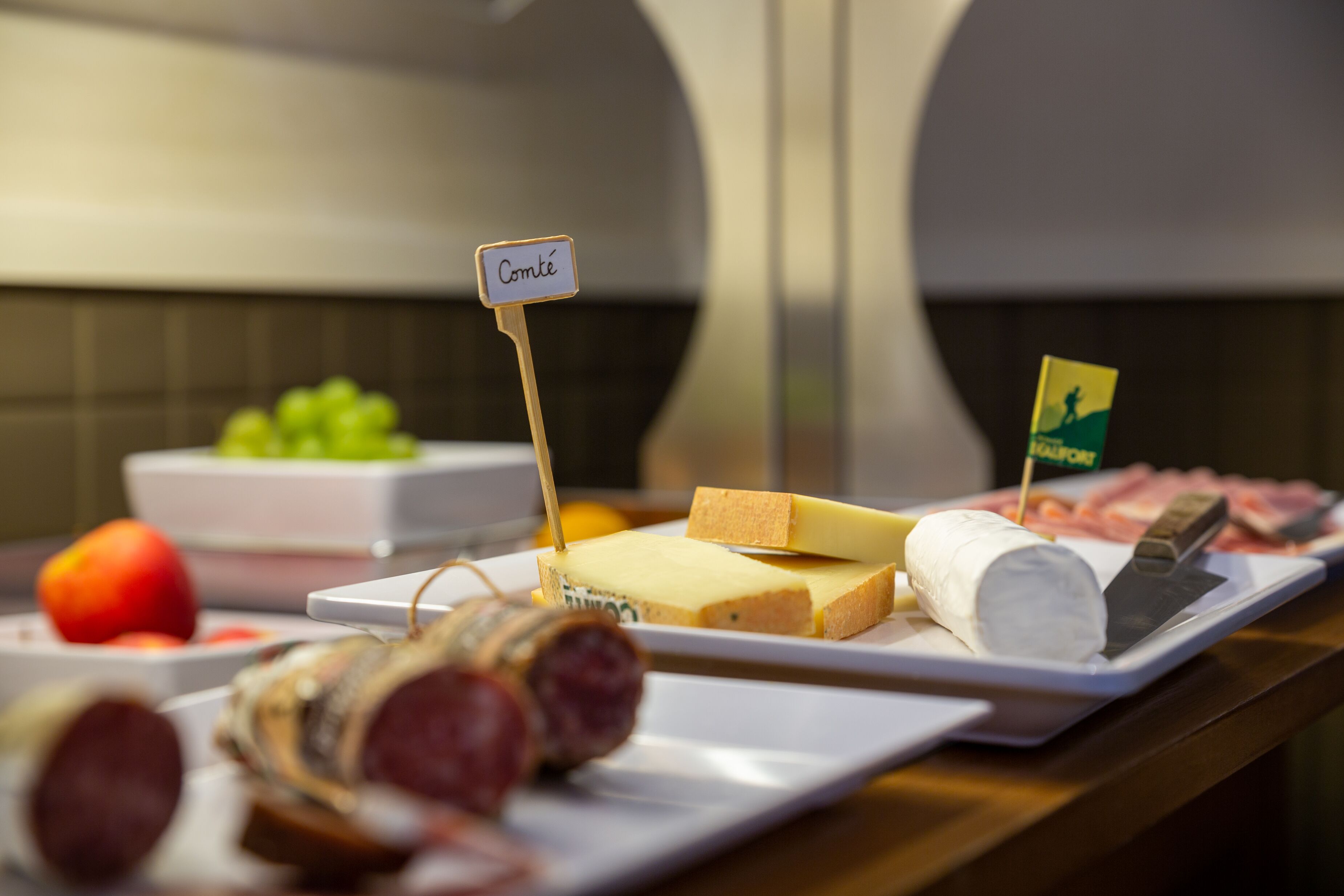 Un buffet proposant une variété de fromages, de viandes et de fruits.