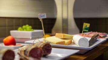 Un buffet proposant une variété de fromages, de viandes et de fruits.