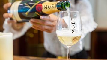 Uma pessoa servindo champanhe em uma taça com a inscrição 'MOËT'.