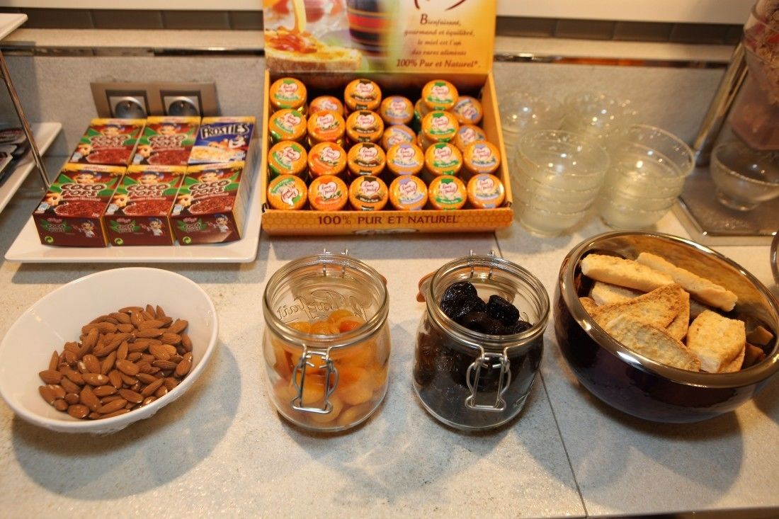A breakfast buffet with various food items including pastries, fruits, and nuts.