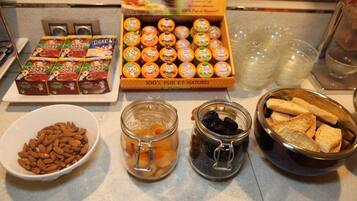 A breakfast buffet with various food items including pastries, fruits, and nuts.