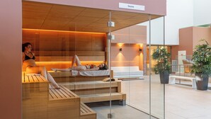 A sauna area with wooden benches and a glass partition. - Hôtel Lyon Métropole & Spa (Lyon)