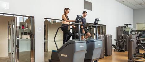 Un gimnasio con cintas de correr y máquinas de pesas.