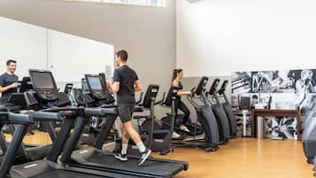 Een sportschool met loopbanden, een whiteboard en trainingsapparatuur.