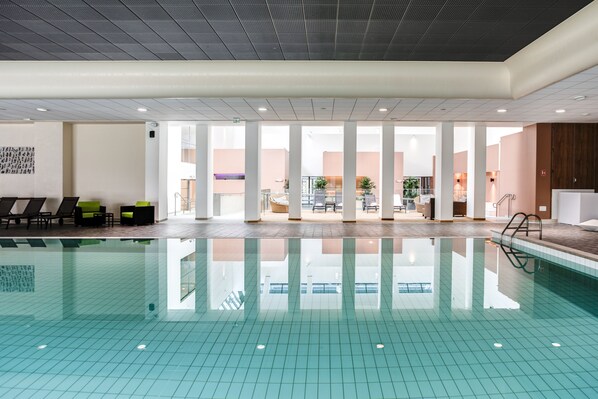 Una piscina techada, una piscina al aire libre de temporada, sombrillas
