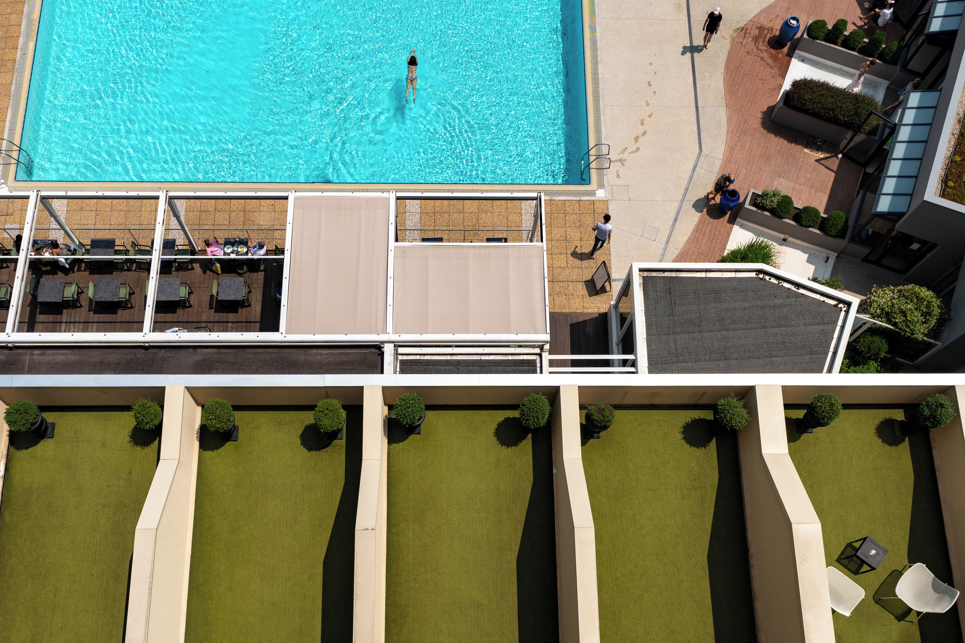 Vue aérienne d’un hôtel doté d’une piscine, d’un espace de détente extérieur et d’un jardin aménagé.