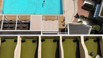 Vue aérienne d’un hôtel doté d’une piscine, d’un espace de détente extérieur et d’un jardin aménagé.