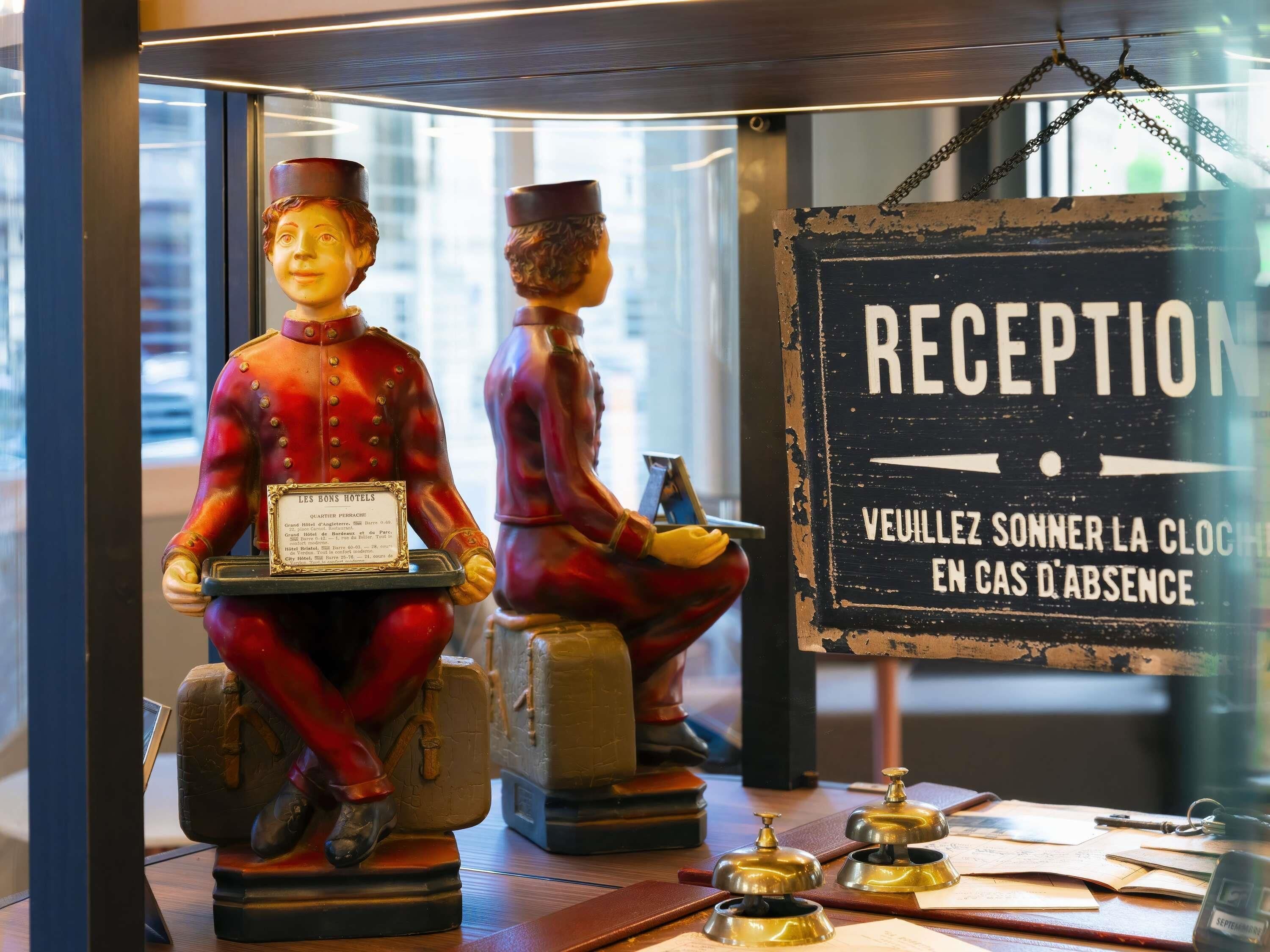 A reception desk with a sign that reads 'RECEPTION' and a message in French.