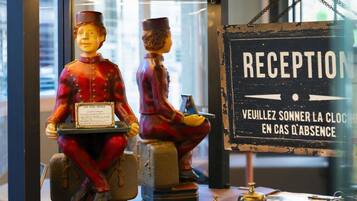 A reception desk with a sign that reads 'RECEPTION' and a message in French.